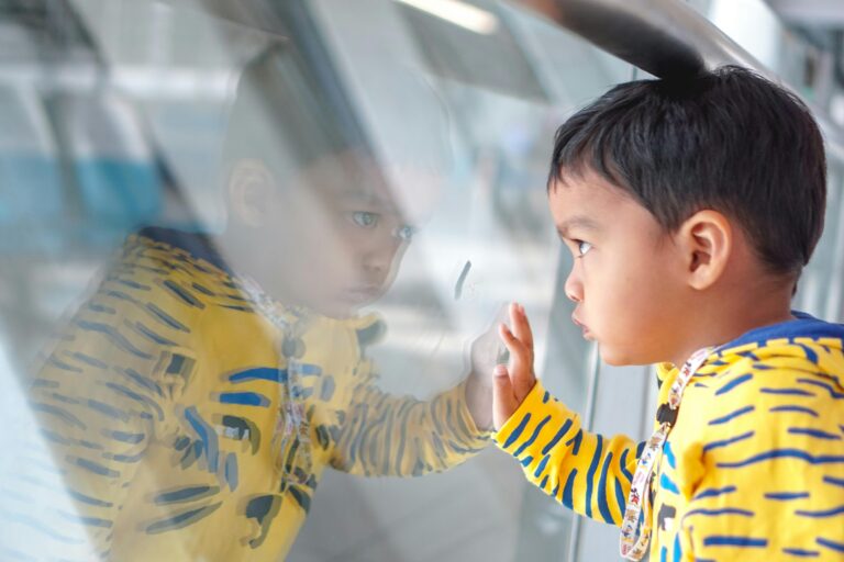 An autistic child looking out of glass and trying to figuring out things