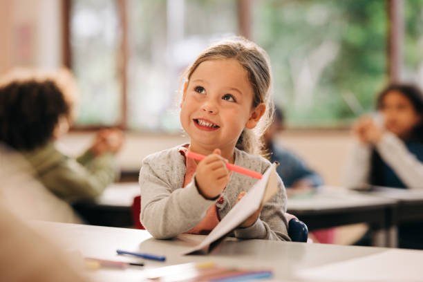 little girl pointing to the paper in before school activity