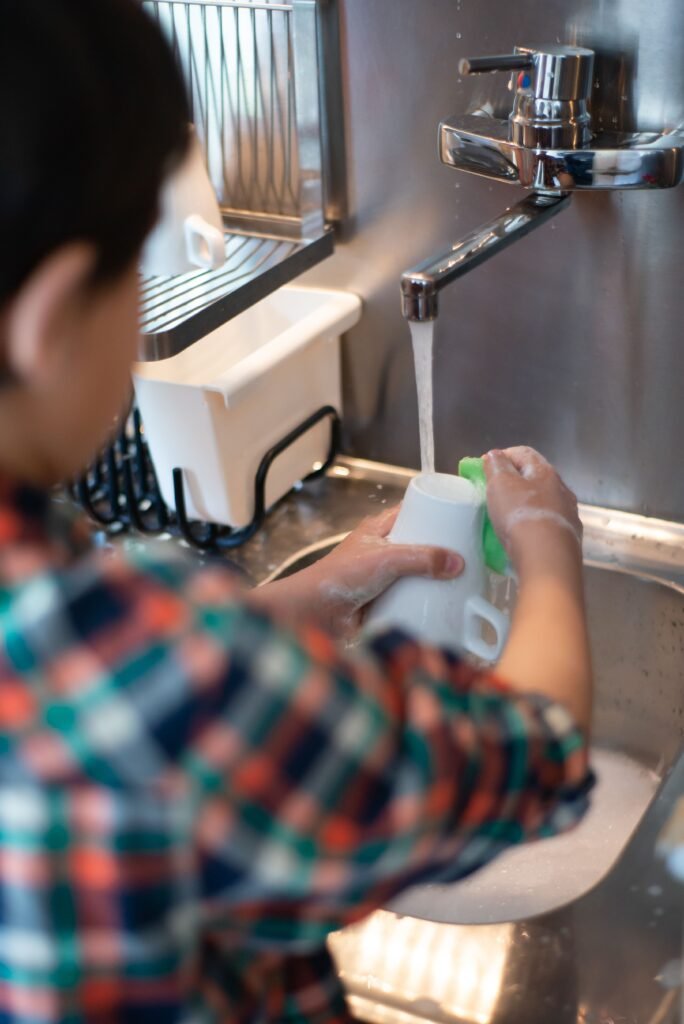 kid is washing glass independently